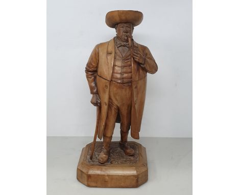 A Treen Tobacco Jar in the form of a Gentleman smoking a Pipe, with Walking Stick, wearing Tricorn Hat and Coat on rectangula