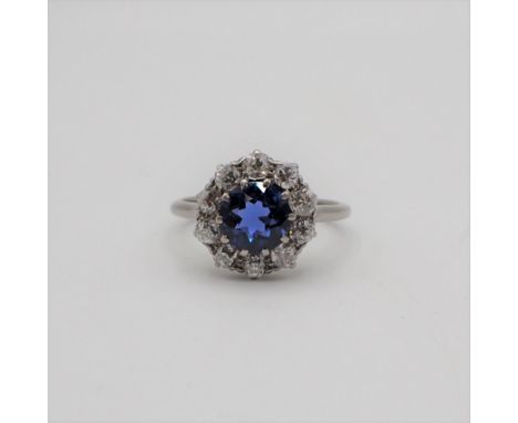 A Sapphire and Diamond Cluster Ring claw-set round sapphire within a frame of ten old-cut diamonds, ring size M, unmarked, un