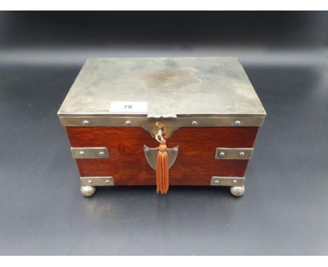 A Victorian plated mounted oak Tea Caddy with scroll engraved lid enclosing two lidded divisions, ornate handles, raised on b