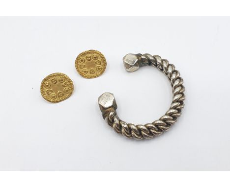 A white metal Manilla Torque Bangle, approx 123gms and a pair of yellow metal Earrings formed as early coins, approx 8.3gms, 