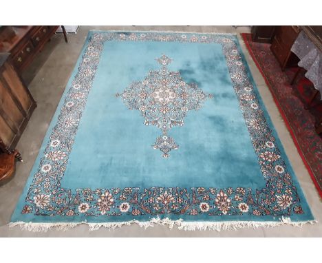 A Chinese blue ground Carpet with central floral medallion and with floral scroll border in camel, rust and cream, 14ft x 11f