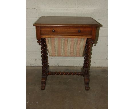 A Victorian mahogany work table, having a frieze drawer above a sliding work basket, on spiral turned legs and stretchers, 56