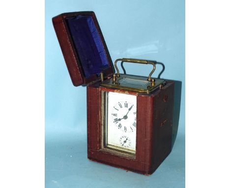 An early-20th century French brass carriage clock, the white enamel face having Roman numerals above an alarm dial with Arabi