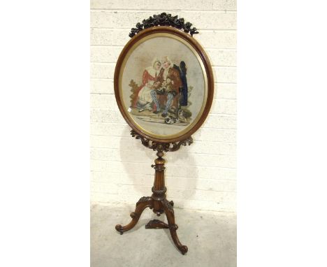 A William IV rosewood tripod fire screen with oval needlework panel depicting two figures seated on a bench, with a blue robe