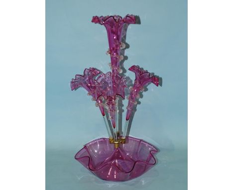 A late-19th century cranberry glass epergne, the central trumpet vase flanked by three further vases, with applied clear glas