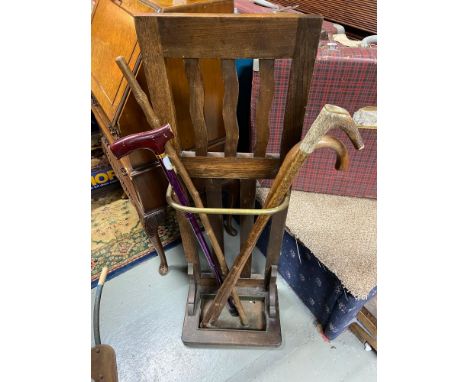Antique stick stand designed with a gilt brass bar section, Contains four various walking sticks. 
