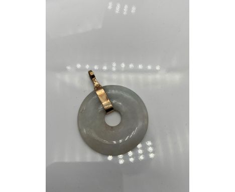 A Tested [14ct -15ct] gold and pale green jade pendant. 