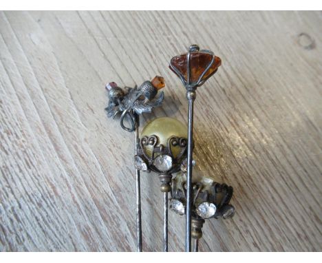 Silver mounted thistle design stickpin together with three other stick pins 