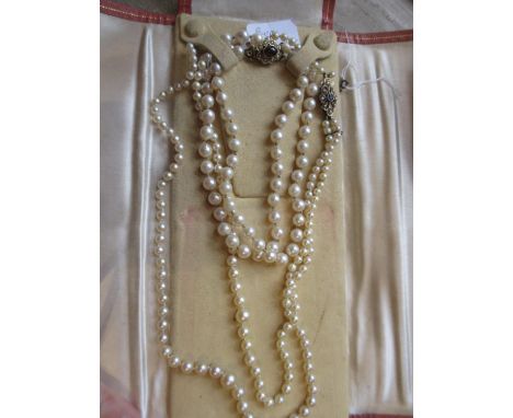 Single row uniform cultured pearl necklace with a 9ct gold cabochon garnet and split pearl set clasp, together with a double 