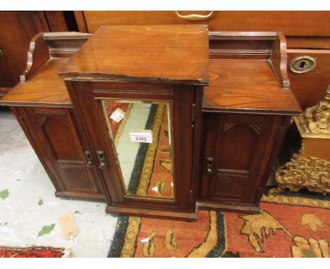 Late Victorian oak hanging smokers cabinet with a centre mirrored door flanked by two arched panel doors (at fault) 