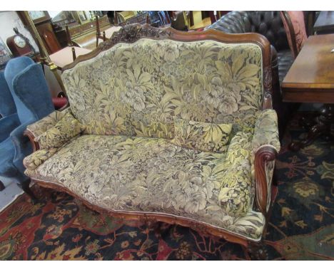 Good quality 19th Century French rosewood and upholstered sofa with a floral carved back rail, scroll arms, a shaped frieze a