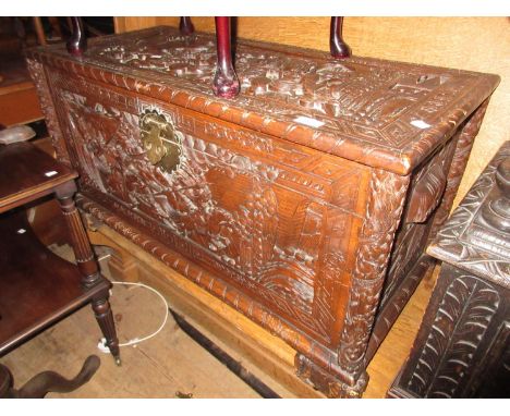 Early to mid 20th Century oriental carved camphor wood trunk decorated in high relief, 37ins wide37ins wide x 21ins deep x 24