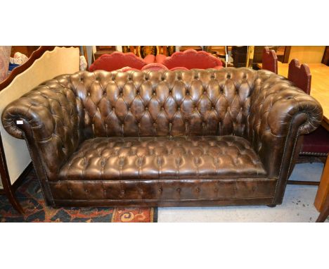 Brown leather button upholstered high back Chesterfield sofa with buttoned seat raised on bun supports, 82ins wide x 37ins hi