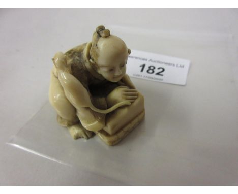Composition netsuke in the form of a crouching man with a cat 