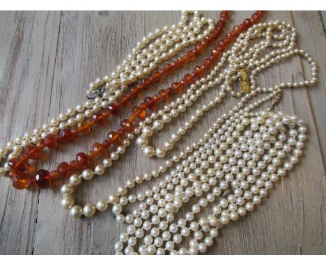 Graduated cultured pearl necklace with a 9ct gold clasp together with three simulated pearl necklaces and a reconstituted amb