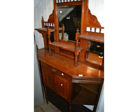 Late Victorian walnut chiffonier in Aesthetic style with a mirrored shelf back above a drawer, cupboards and open shelves 