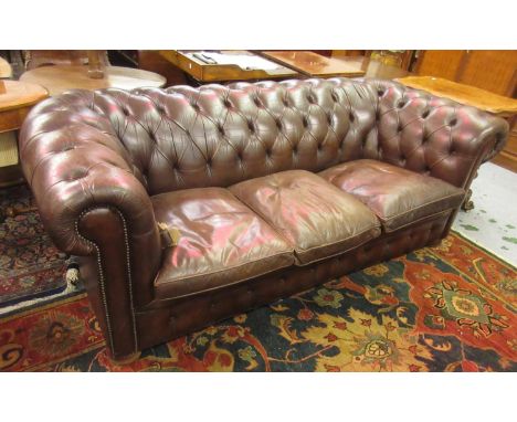 20th Century brown button backed leather upholstered Chesterfield sofa with loose cushions on bun supportsThis is 20th Centur