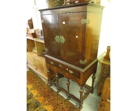 Burr walnut side cabinet on stand in 18th Century style, the moulded top above two flush panel doors with decorative brass hi