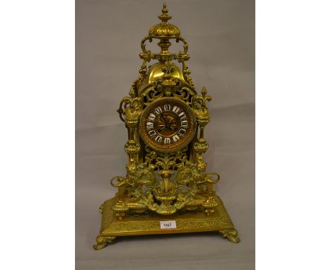Large 19th Century gilt brass mantel clock with urn surmount, the case of open work design and decorated at the base with fig