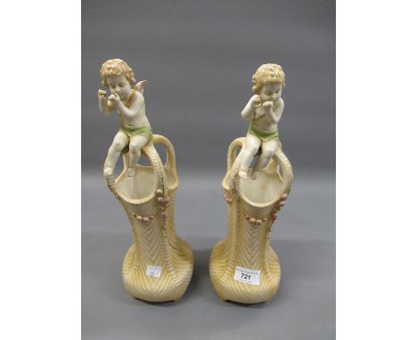 Pair of Royal Vienna Wahliss bisque vases of waisted basket form, each surmounted by a seated figure of a cherub, 14ins high 