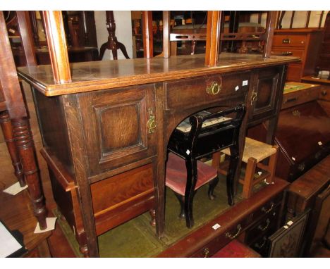 Arts and Crafts oak side table with a centre drawer flanked by two panel doors, raised on square tapering supports 