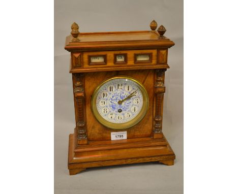 19th Century walnut mantel clock having integral calendar for month, date and day above a circular blue and white porcelain d