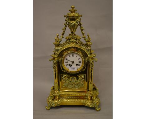 Large 19th Century French gilt brass mantel clock, the broken arch case with urn and floral swag surmount decorated in relief