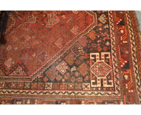 Shiraz carpet of medallion design on a red and black ground with borders, 6.5ft x 9.5ft approximately 