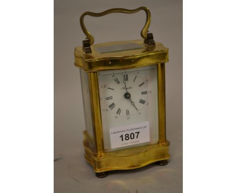 L' Epee French gilt brass carriage clock of serpentine shape, the enamel dial with Arabic and Roman numerals 