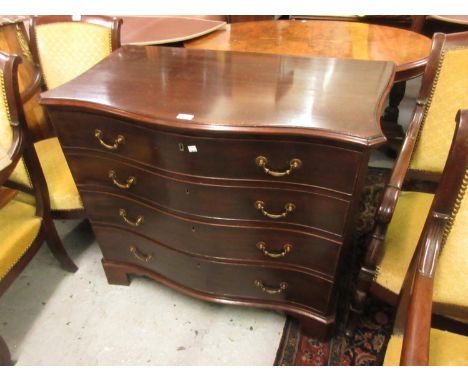 George III mahogany serpentine shaped dressing commode, the moulded top above four drawers with brass handles, the top drawer