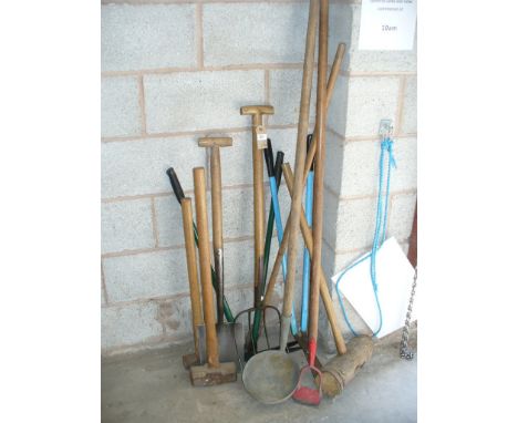 A collection of garden tools including spade, sledge hammer and fork