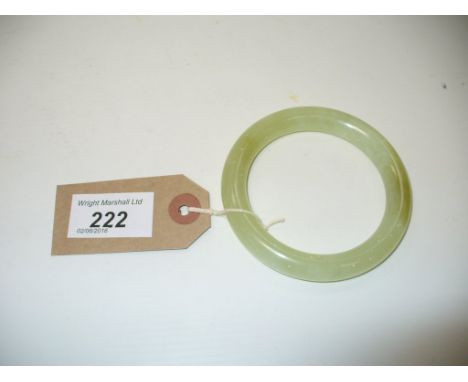 A jade bangle, of typical light green colour, with white fleck and darker green patches throughout, with a small crack to one