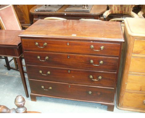 A Georgian mahogany chest of drawers
The rectangular moulded top above four graduated cockbeaded drawers each with brass swan