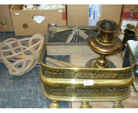 A 19th Century pierced brass fender, carpet beaters, cutlery tray, brass oil lamp, spark guard and carving set.