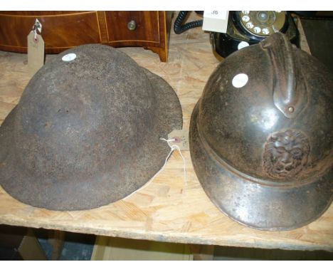 A French WWI metal helmet mounted with a lions mask and a British army helmet. (2)