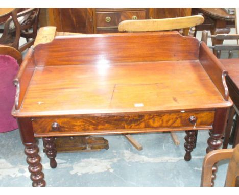 A Victorian mahogany wash stand
The rectangular top with a paper scroll gallery above a single frieze drawer with button hand