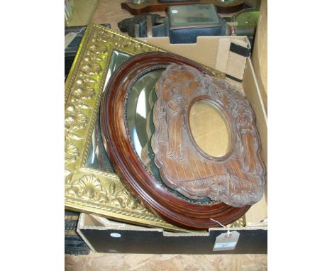 A Carved Japanese hardwood oval wall mirror, a brass framed wall mirror embossed with shells and a third mirror. (3)