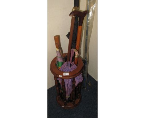 Modern stick stand containing assortment of walking sticks, umbrellas and parasols.