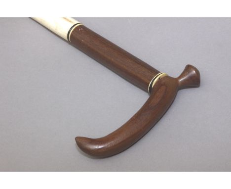 A 20th century walking stick. Carved walnut, bone and ebony sections shaft and handle with a carved antler tip, 82 cm. long.