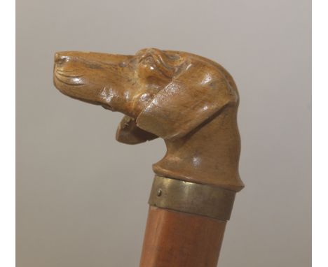 A 20th century walking stick. A carved and vernished wood shaft with a boxwood handle carved in the shape of a dog head with 