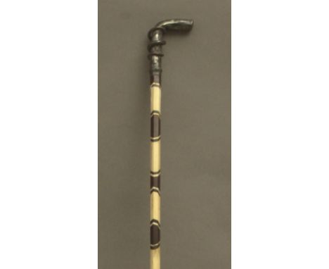 A first third of 20th century walking stick. Carved ivory and mahogany marquetry shaft and a silver handle, 86 cm. long. Elep