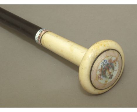 A 19th century walking stick, probably French. Carved and ebonized wood shaft with a carved ivory and guilloché enamel handle