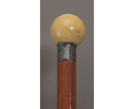 A 20th century walking stick. Having a fruitwood shaft and an ivory handle carved in the shape of half sphere, having a compa