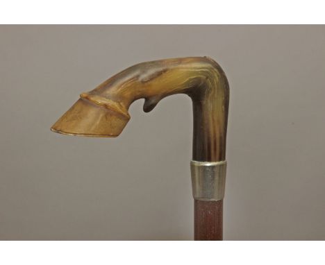 A 20th century walking stick. Carved and lacquer wood shaft and with a stag horn handle carved in the shape of a horse's leg 