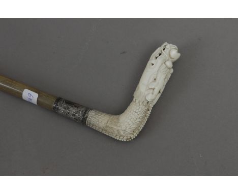 A 19th century Chinese walking stick. Carved rhino horn shaft and an ivory handle carved in the shape of a dragon's head and 