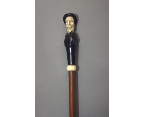 A first third of 20th century walking stick. Carved wood and ebony shaft with an ivory handle carved in the shape of the bust