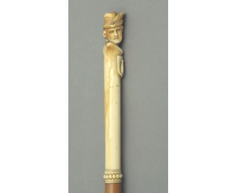 A walking stick circa 1900. Carved fruitwood shaft and an ivory handle carved in the shape of the bust of a dame wearing a ha