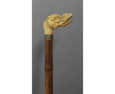 A 19th century oriental walking stick. Carved bamboo shaft and and an ivory handle carved in the shape of a dragon bust with 