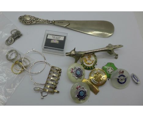 A silver handled shoe horn, Birmingham 1904, a silver toe ring, other silver, regimental badges, costume rings and a knife re