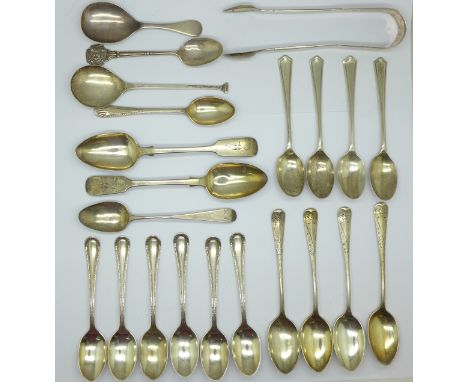 A collection of silver teaspoons, a silver caddy spoon and a pair of silver sugar bows, 330g 